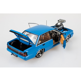 Rear three-quarter view of blue Holden VL Calais diecast with open door and boot, tan interior and supercharged engine